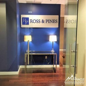 law firm lobby sign uses acrylic on a brushed metal sign